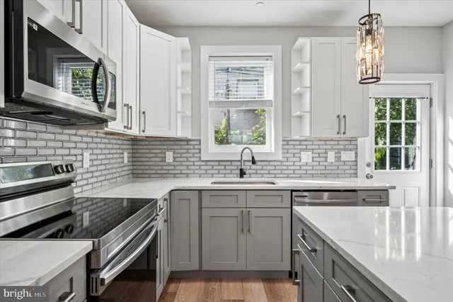 a kitchen with a sink stove top oven and cabinets