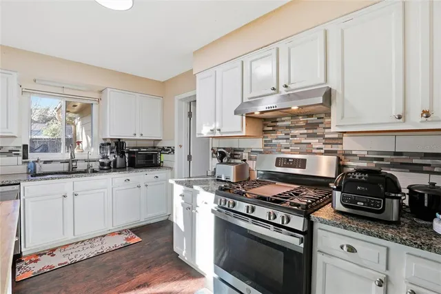 a kitchen with refrigerator cabinets and wooden floor