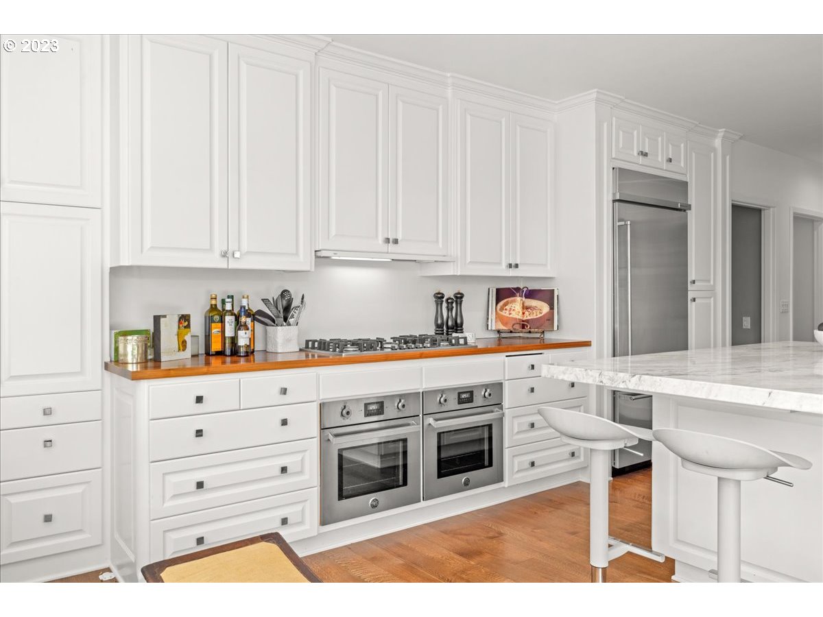 7470 Southwest Westgate Way Portland, OR 97225 - Photo 17 of 41 a kitchen with stainless steel appliances granite countertop a stove a sink and white cabinets