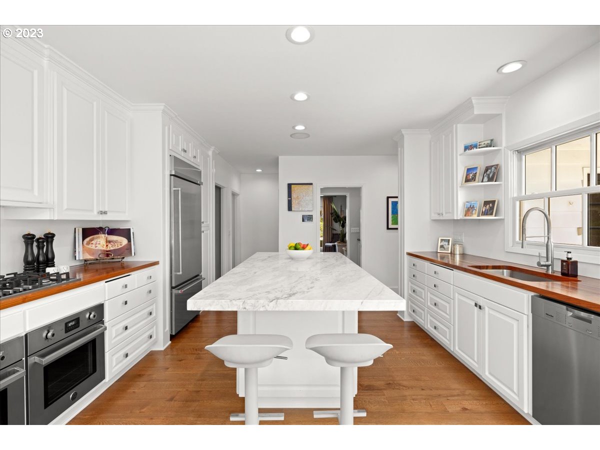 7470 Southwest Westgate Way Portland, OR 97225 - Photo 18 of 41 a large kitchen with granite countertop a large counter top cabinets and stainless steel appliances