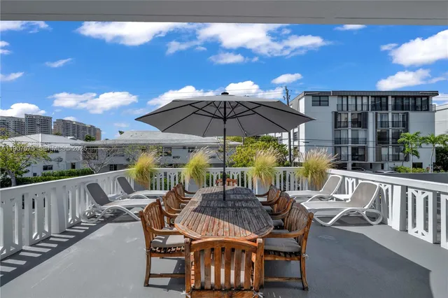 a view of chair and tables with umbrella in the balcony