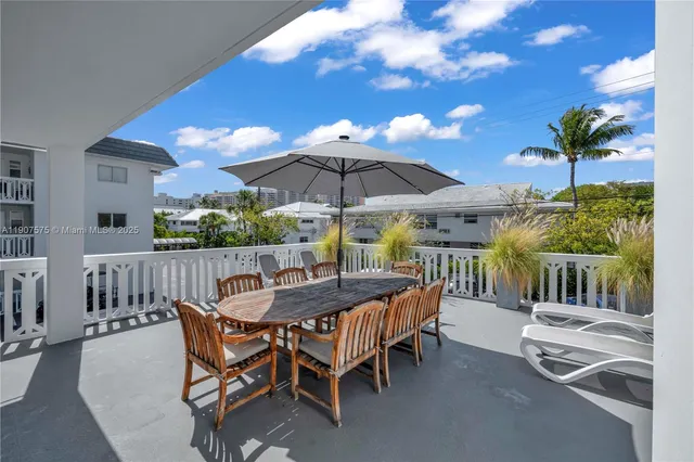 a view of a patio with a table and chairs under an umbrella