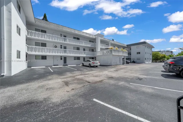 a view of building with cars parked in front of it