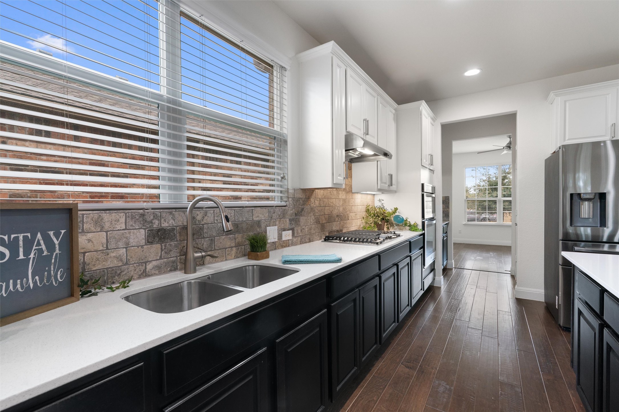 706 Kite Ridge Street Georgetown, TX 78633 - Photo 10 of 37 a kitchen with stainless steel appliances kitchen island granite countertop a sink a counter space cabinets and wooden floor