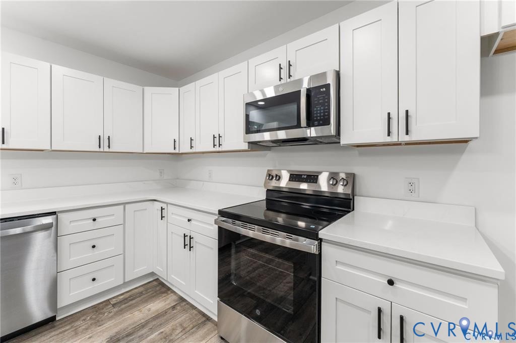 308 Crump Drive Ruther Glen, VA 22546 - Photo 8 of 24 a kitchen with white cabinets and stainless steel appliances