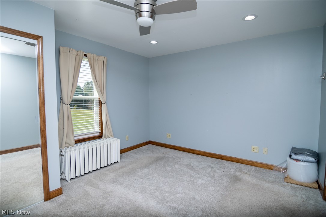 53341 Key Bellaire Road Bellaire, OH 43906 - Photo 20 of 48 Carpeted empty room with radiator heating unit, recessed lighting, and ceiling fan