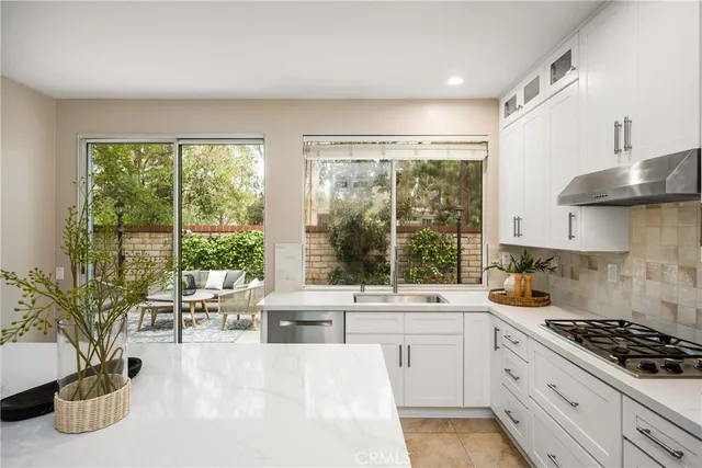 a view of center island with a sink and cabinets