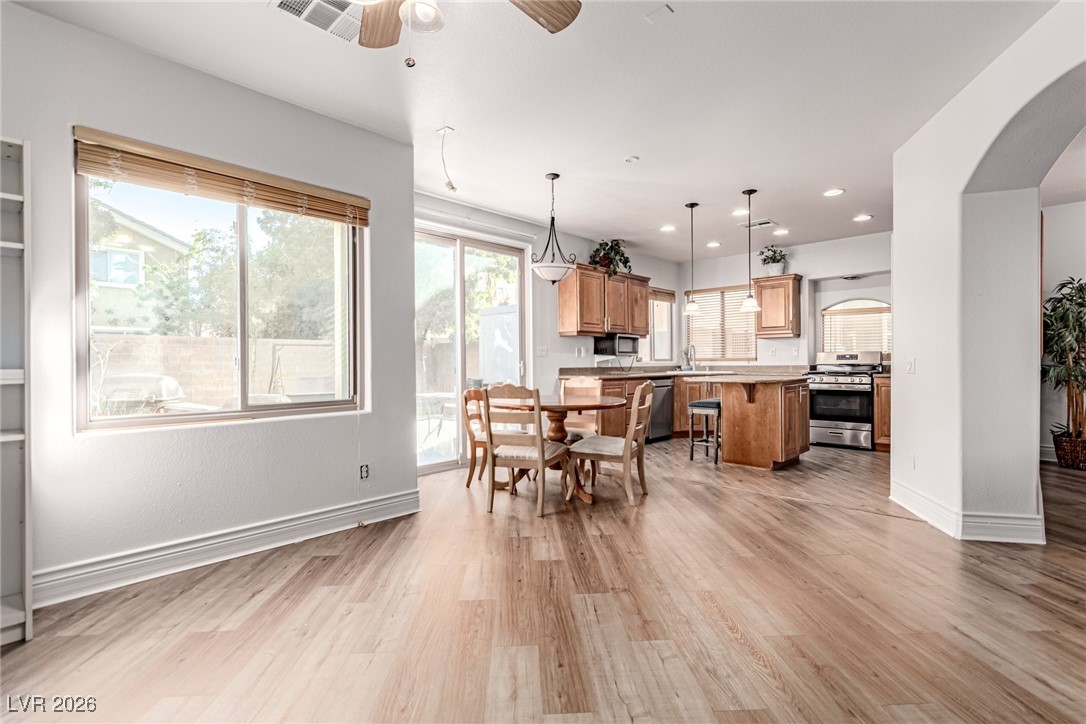 135 Broken Putter Way Las Vegas, NV 89148 - Photo 13 of 40 Dining area with light wood-style flooring, arched walkways, recessed lighting, and a ceiling fan