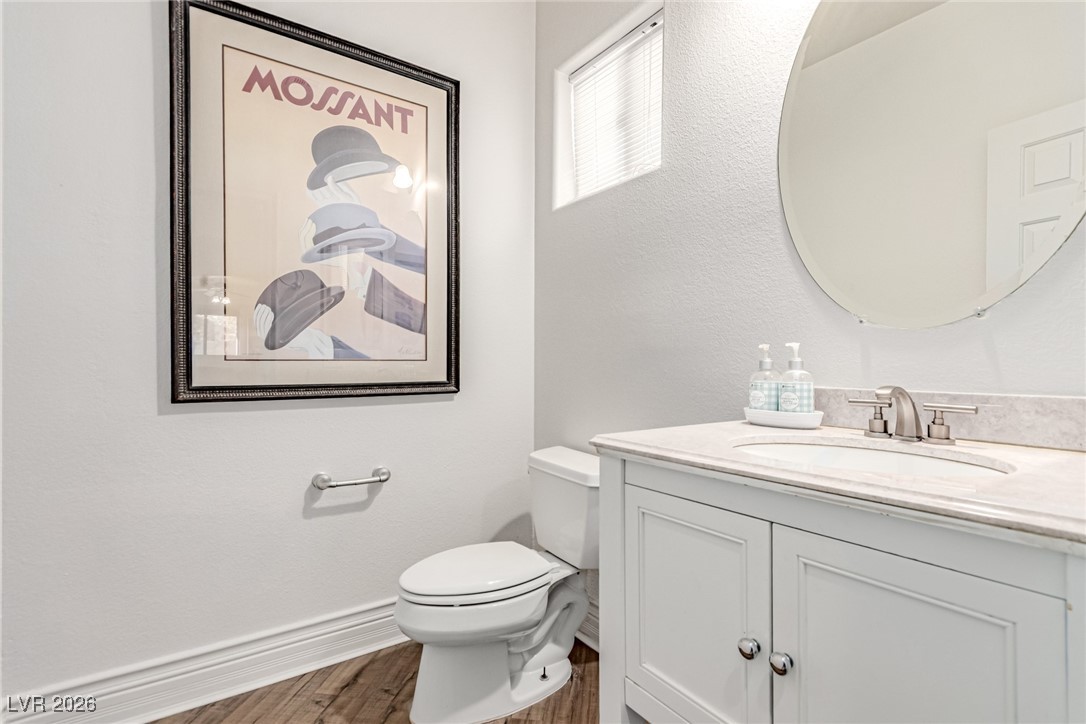 135 Broken Putter Way Las Vegas, NV 89148 - Photo 15 of 40 downstairs Bathroom with vanity, dark wood-style floors, and a textured wall