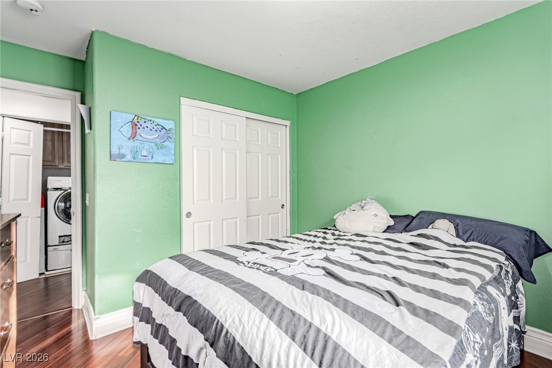 135 Broken Putter Way Las Vegas, NV 89148 - Photo 22 of 40 upstairs Bedroom 3 with dark wood-style flooring, a closet, and washer / dryer