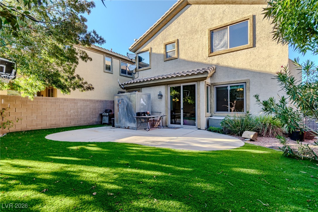 135 Broken Putter Way Las Vegas, NV 89148 - Photo 25 of 40 Back of house with stucco siding and a patio area