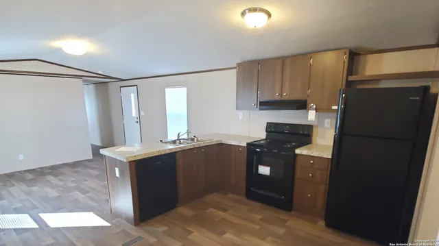 a kitchen with stainless steel appliances granite countertop a refrigerator and a stove top oven