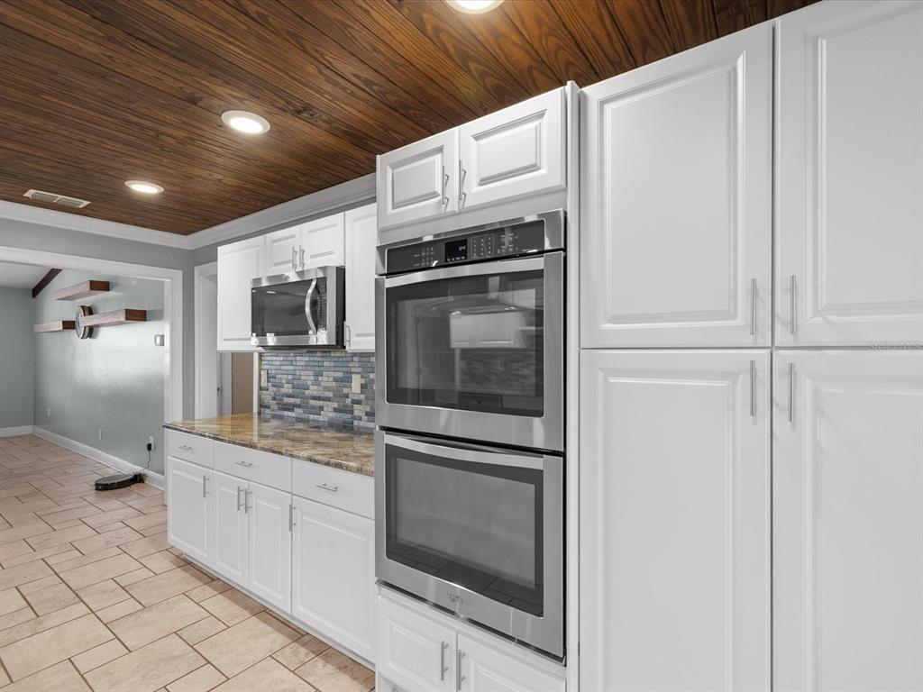 5904 Springrun Court Holiday, FL 34690 - Photo 18 of 53 a kitchen with granite countertop white cabinets and stainless steel appliances