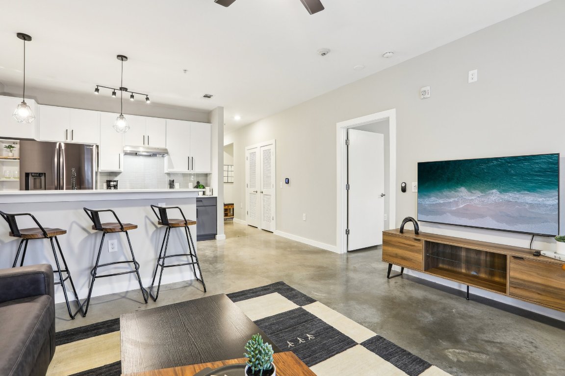 2505 Thornton Road, Unit 1107 Austin, TX 78704 - Photo 4 of 32 a living room with stainless steel appliances kitchen island granite countertop furniture and a flat screen tv