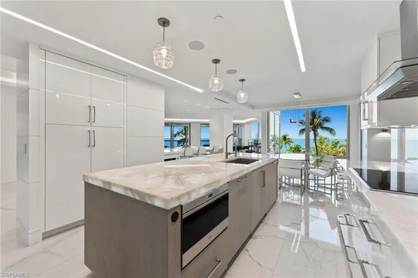 a large kitchen with kitchen island a large counter top and stainless steel appliances