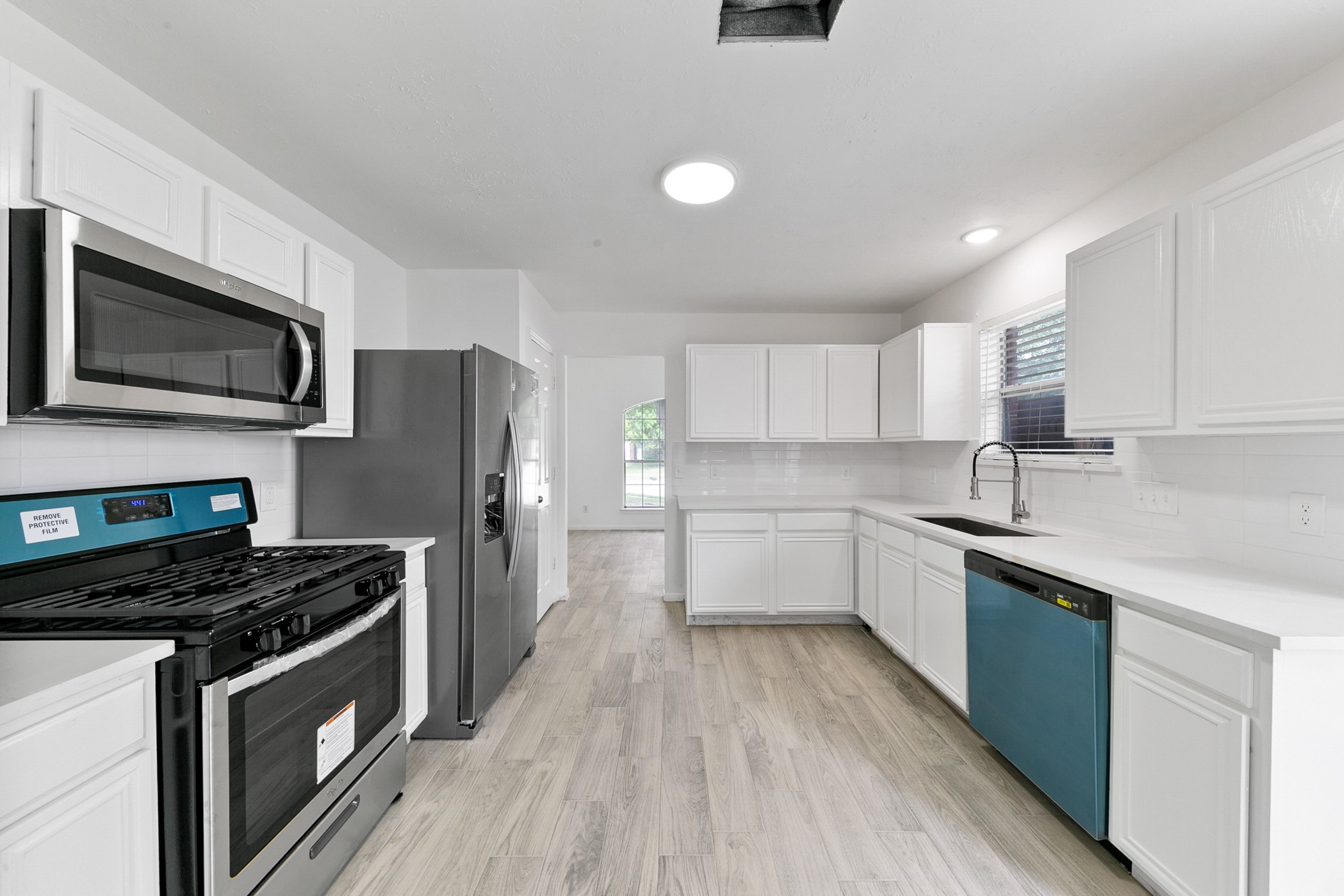 12014 Raven View Drive Houston, TX 77067 - Photo 28 of 29 This modern kitchen features sleek stainless steel appliances, white cabinetry, and a spacious layout with ample natural light, perfect for culinary enthusiasts.