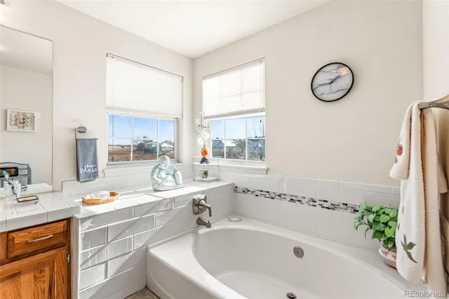 a bathroom with a granite countertop sink and a bathtub