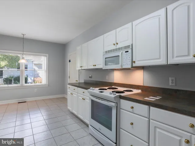 a large kitchen with granite countertop a stove a sink dishwasher and a refrigerator