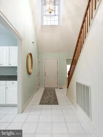 a view of a hallway with entryway wooden floor windows and a kitchen