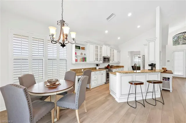 a kitchen with granite countertop white cabinets and chairs