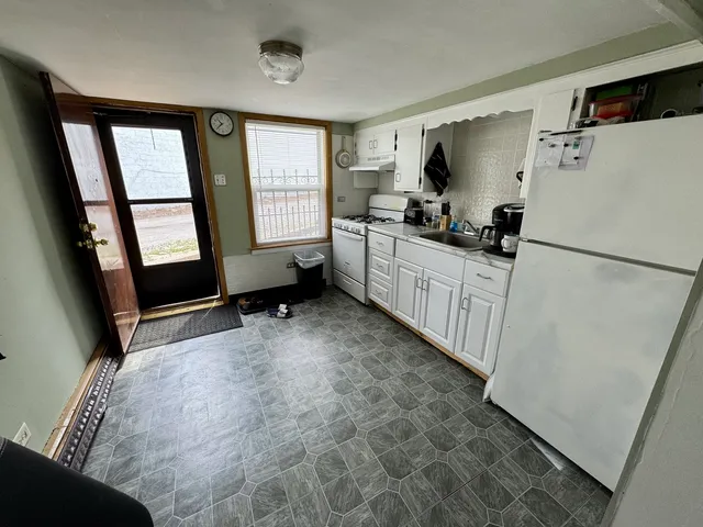 a kitchen with a refrigerator a stove top oven and a window