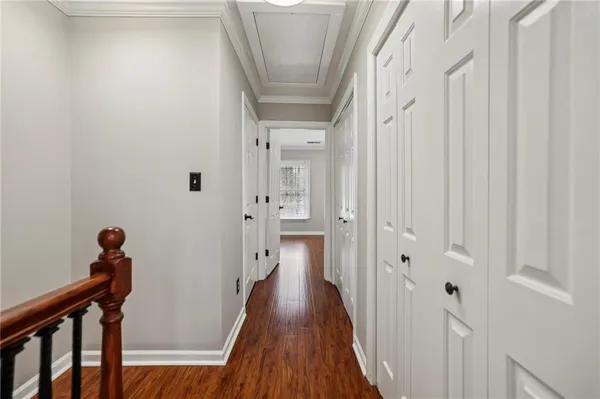 a view of a hallway with wooden floor and staircase