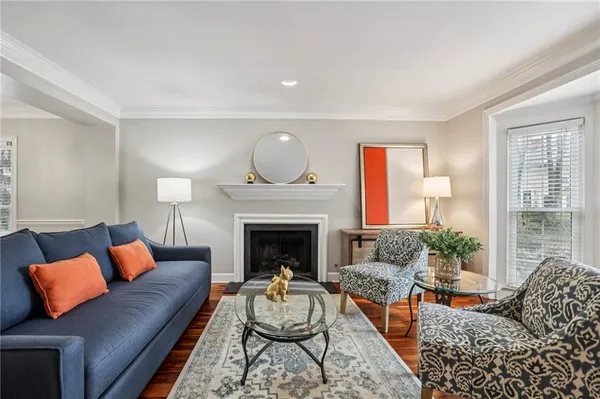 a living room with furniture fireplace and a large window