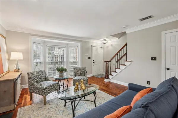 a living room with furniture and wooden floor