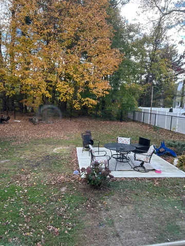 a view of a patio with table and chairs under an umbrella