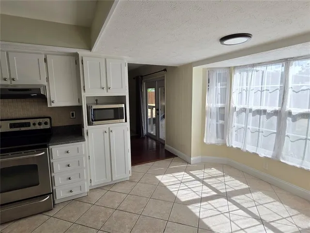 a kitchen with white cabinets and appliances