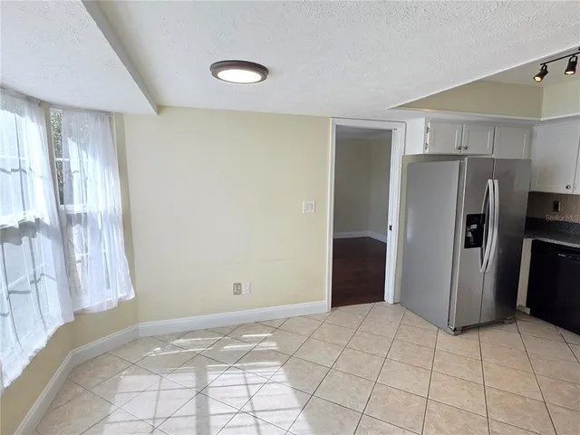 a view of kitchen with refrigerator cabinets and wooden floor