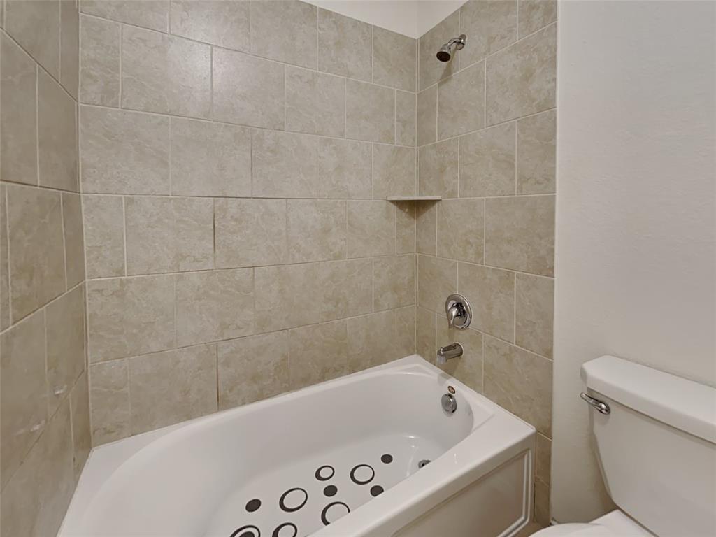 253 Pitt Circle Fate, TX 75189 - Photo 16 of 22 a bathroom with a bathtub and toilet