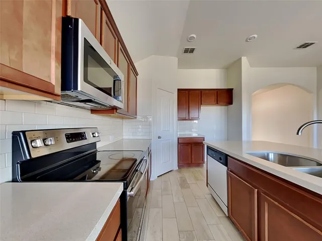 a kitchen with stainless steel appliances a stove a sink and a microwave