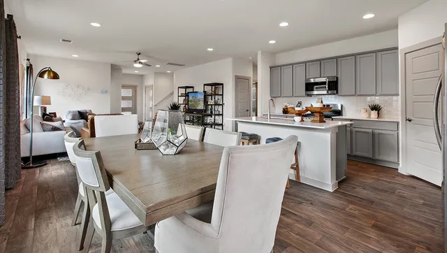 a view of kitchen with refrigerator a stove and wooden floor
