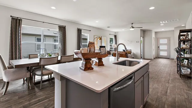 a kitchen with stainless steel appliances kitchen island granite countertop a stove and a sink
