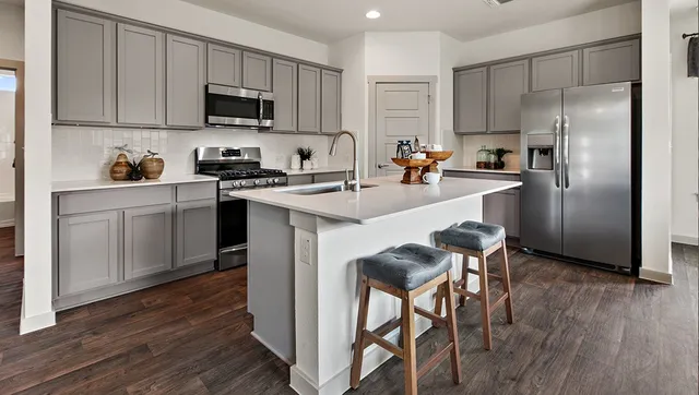 a kitchen with a sink cabinets and wooden floor