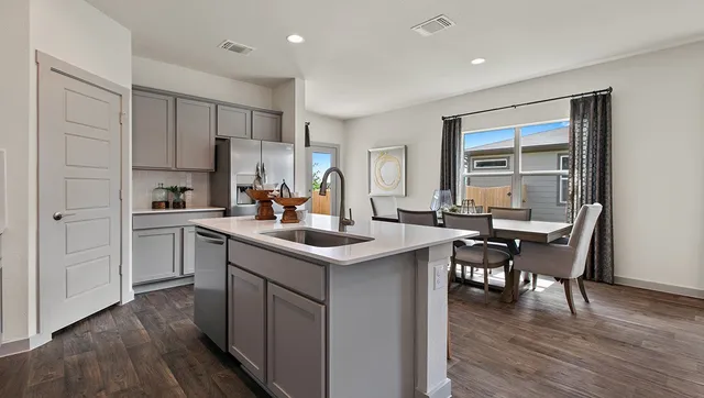 a kitchen with stainless steel appliances granite countertop a sink stove microwave and refrigerator