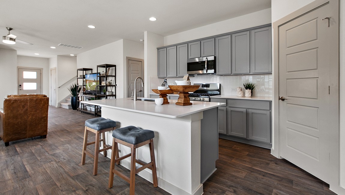 4712 Oxgang Drive Pflugerville, TX 78660 - Photo 16 of 33 a kitchen with a sink a stove a refrigerator cabinets and wooden floor