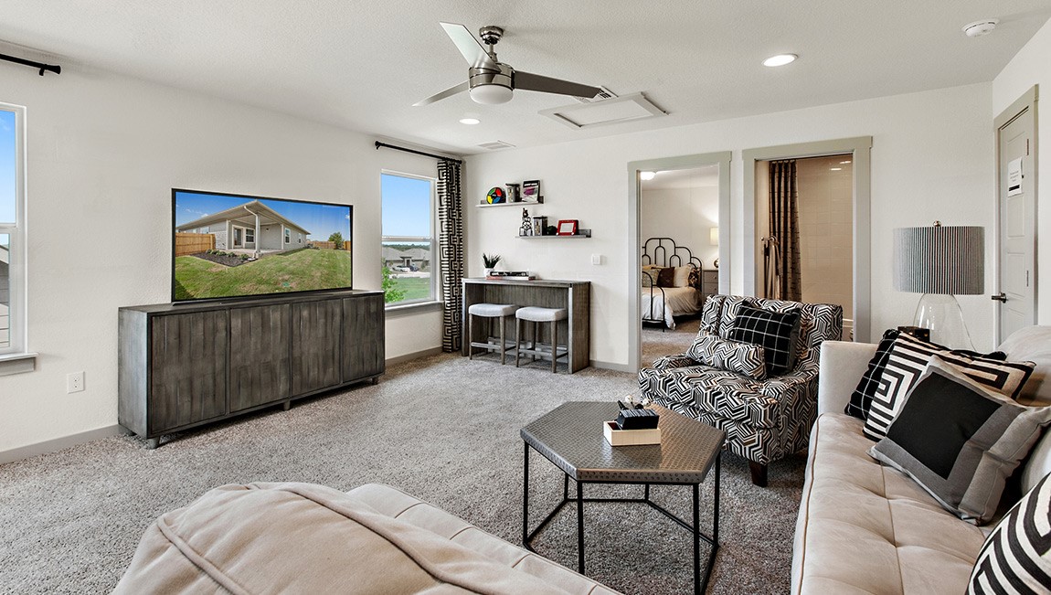4712 Oxgang Drive Pflugerville, TX 78660 - Photo 27 of 33 a living room with furniture a fireplace and a flat screen tv