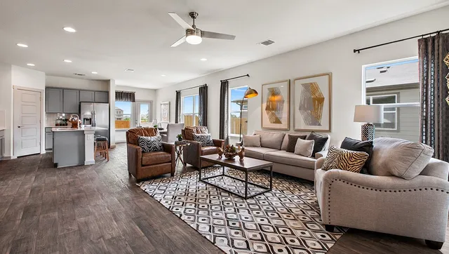 a living room with furniture kitchen view and a window