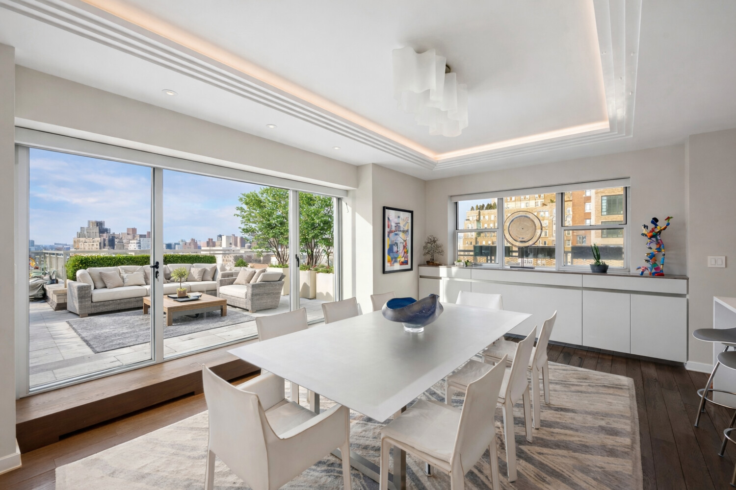 2 5th Avenue, Unit 14R Manhattan, NY 10011 - Photo 2 of 21 a view of a dining room with furniture large windows and wooden floor