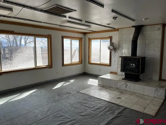 a view of a large house with large trees and wooden fence