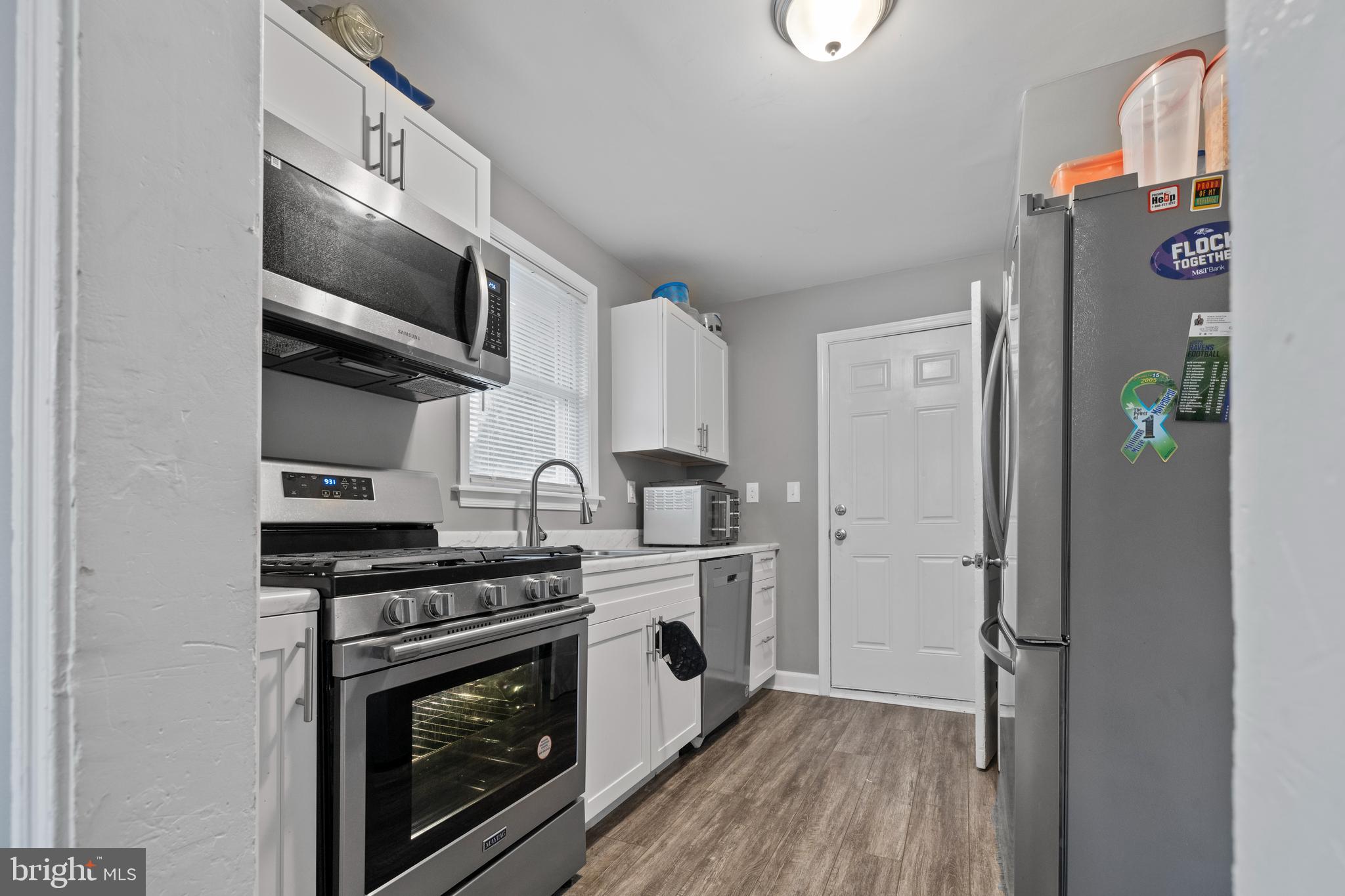 2717 Talbot Road Baltimore, MD 21216 - Photo 6 of 12 a kitchen with stainless steel appliances granite countertop a stove and a microwave