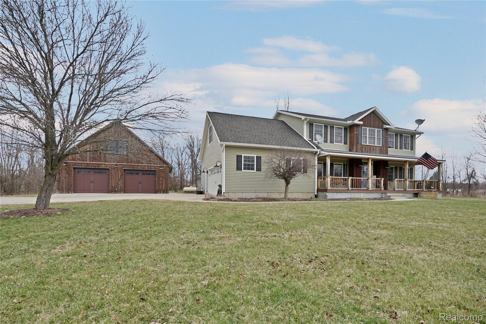 3690 Brauer Road Oxford, MI 48371 - Photo 4 of 63 View of front of property with covered porch, a front yard, an outdoor structure, roof with shingles, and driveway
