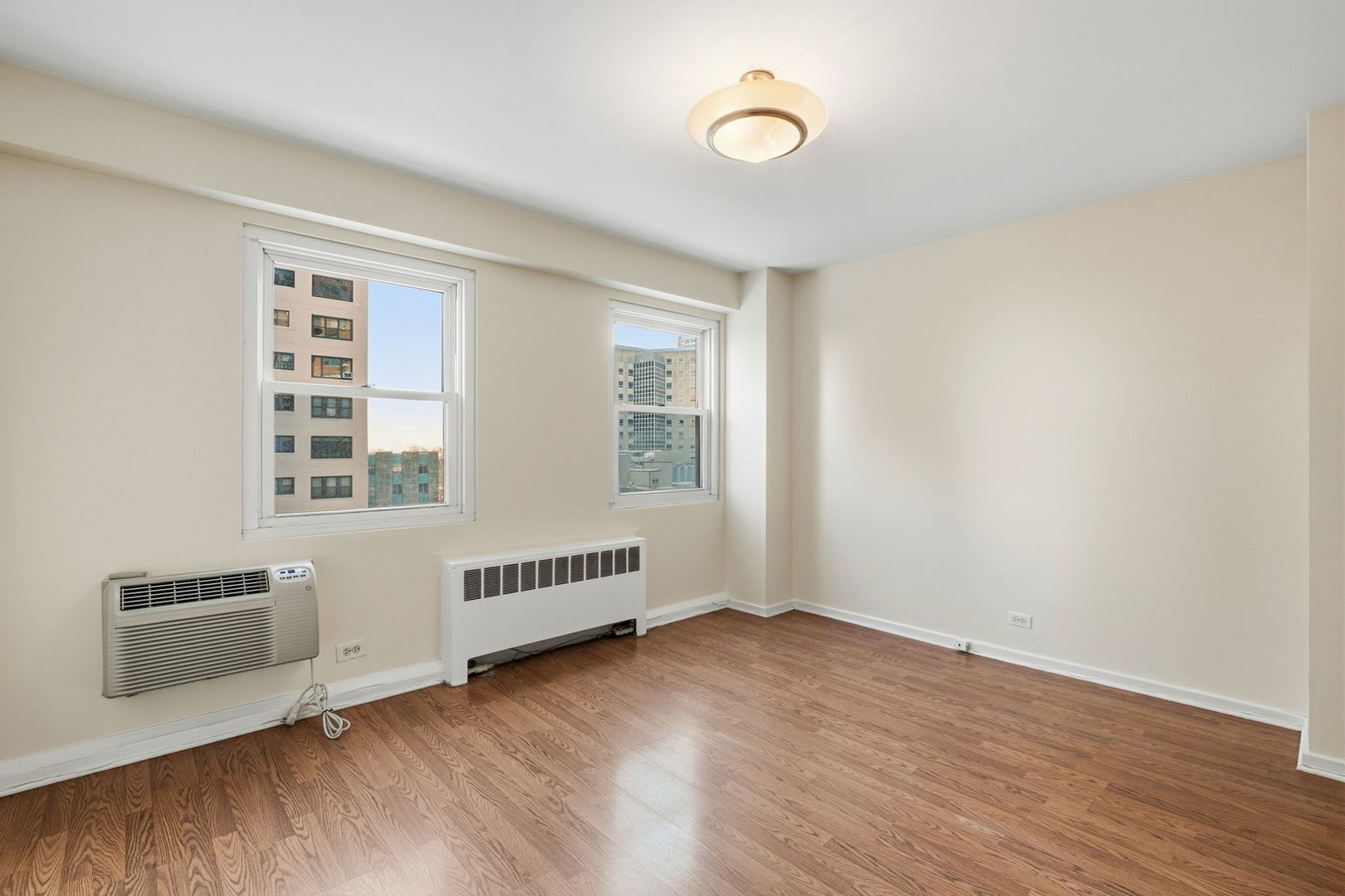 2909 North Sheridan Road, Unit 802 Chicago, IL 60657 - Photo 15 of 22 an empty room with wooden floor and windows