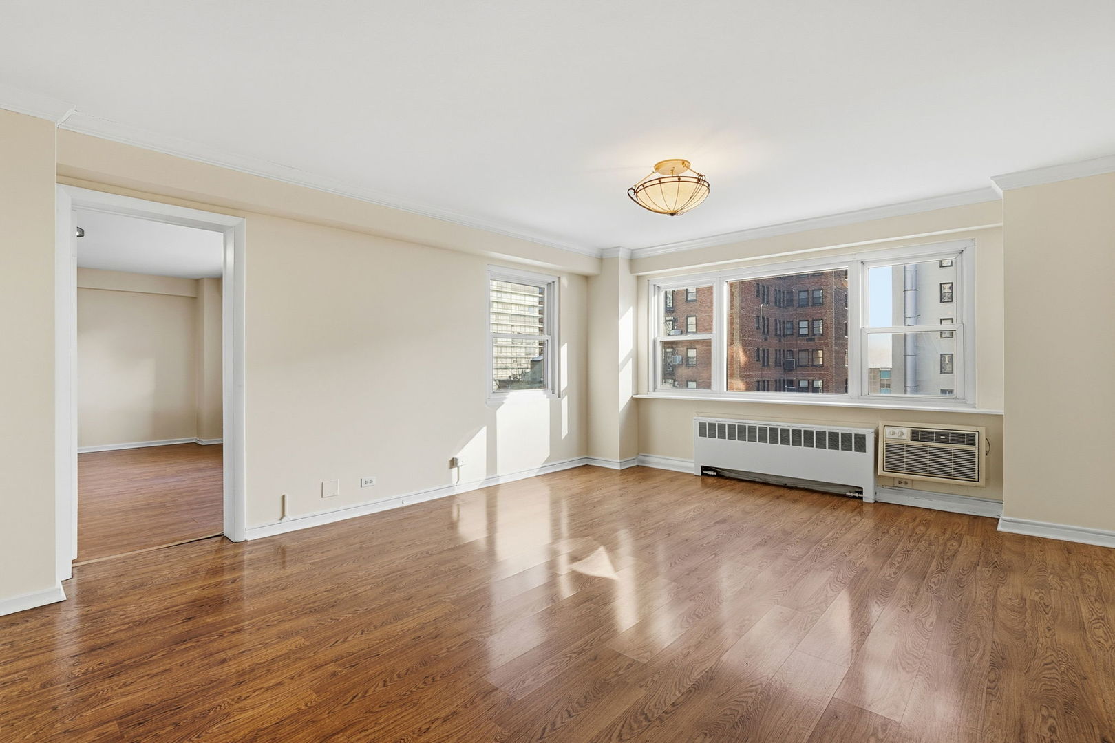 2909 North Sheridan Road, Unit 802 Chicago, IL 60657 - Photo 3 of 22 an empty room with wooden floor and windows
