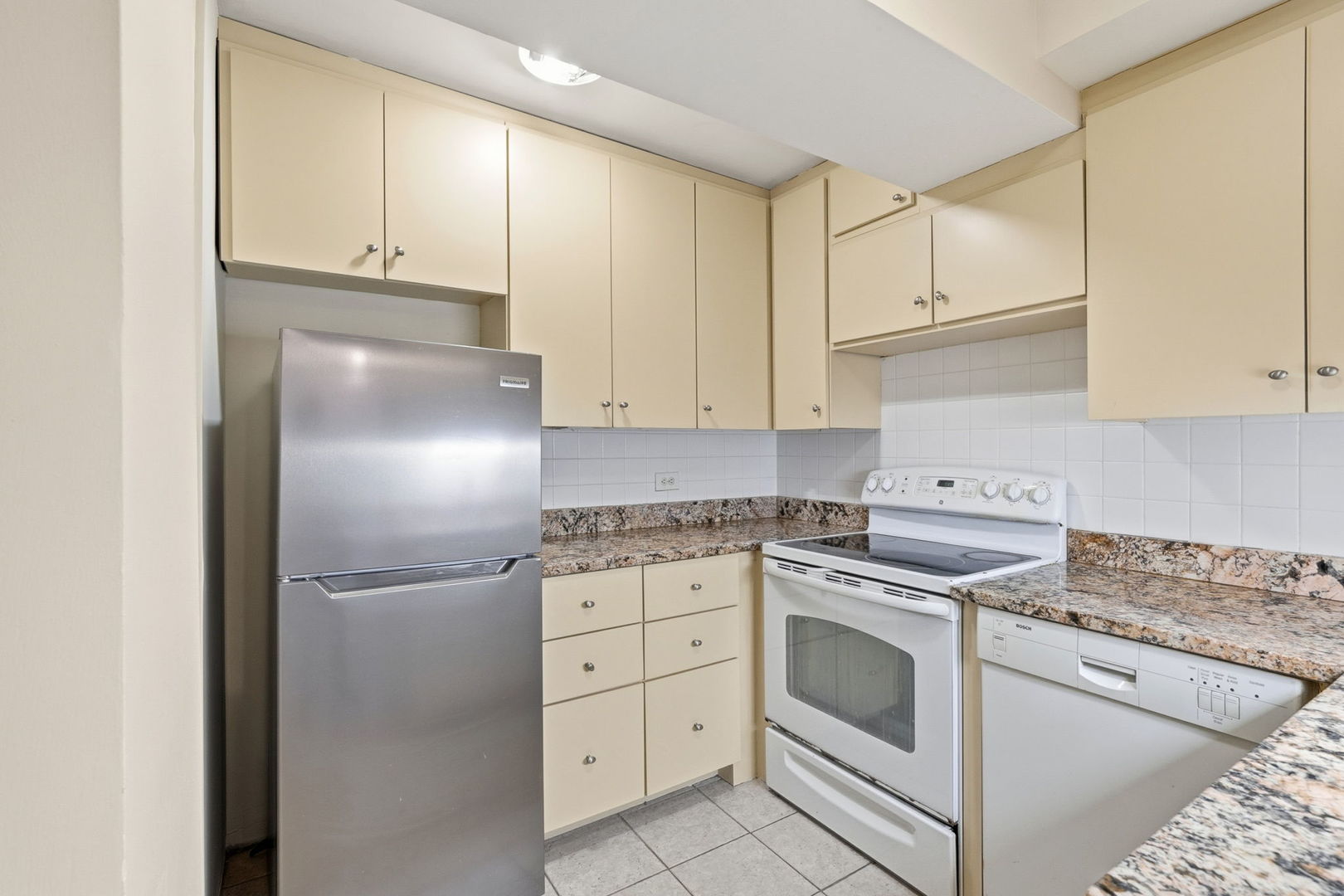 2909 North Sheridan Road, Unit 802 Chicago, IL 60657 - Photo 9 of 22 a kitchen with cabinets stainless steel appliances and a refrigerator
