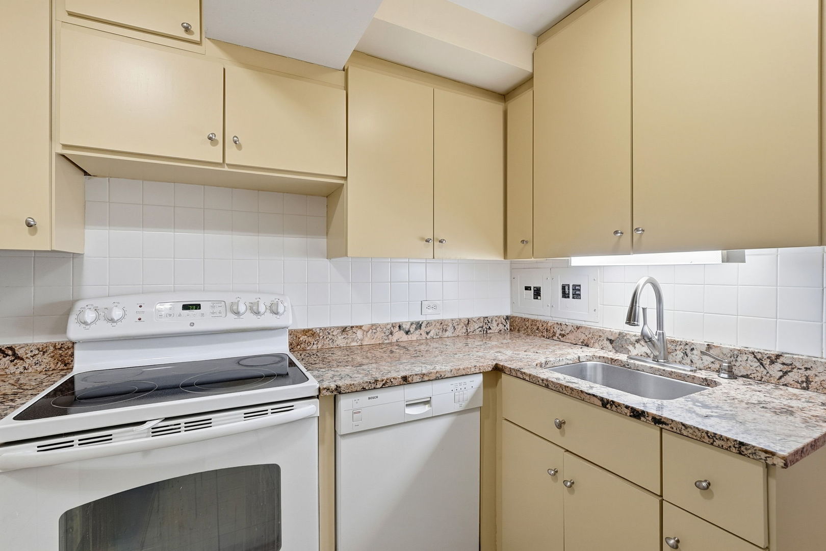 2909 North Sheridan Road, Unit 802 Chicago, IL 60657 - Photo 10 of 22 a kitchen with granite countertop cabinets stainless steel appliances and a sink