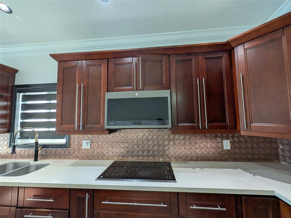 4572 Southwest 14th Street Deerfield Beach, FL 33442 - Photo 14 of 58 a kitchen with granite countertop stainless steel appliances a sink and a counter space