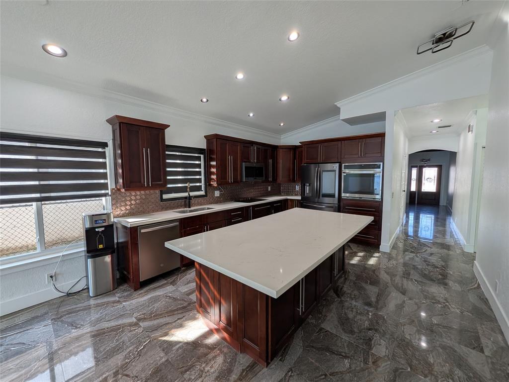 4572 Southwest 14th Street Deerfield Beach, FL 33442 - Photo 9 of 58 a large kitchen with stainless steel appliances a large counter top